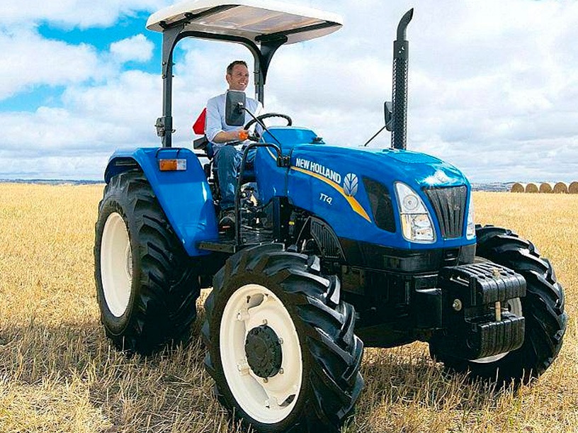 Persona manejando vehículo agrícola new holland