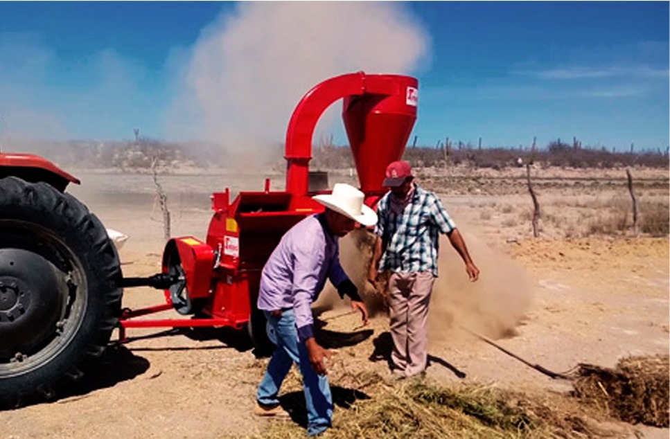 hombres trabajando en el campo con equipo agrícola